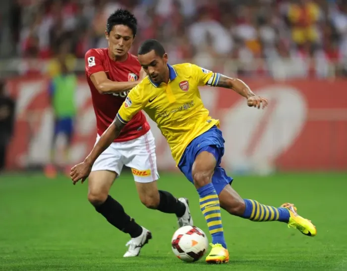 Framed Print : Theo Walcott vs. Kunimitsu Sekiguchi: A Battle for Ball Possession in Arsenal's Pre-Season Clash (2013)