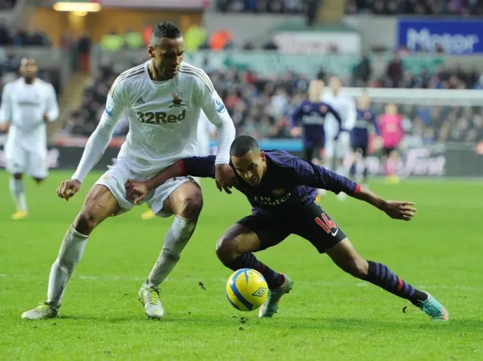Framed Print : Theo Walcott vs. Kyle Bartley: A FA Cup Battle at Swansea Framed Print : Theo Walcott vs. Kyle Bartley: A FA Cup Battle at Swansea