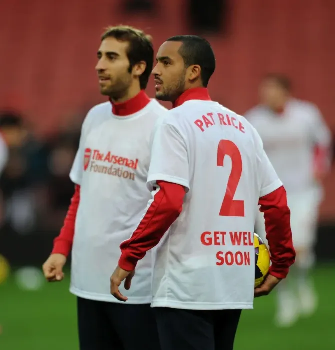 Framed Print : Theo Walcott's Heartfelt Tribute to Pat Rice Before Arsenal vs. Everton, 2013-14