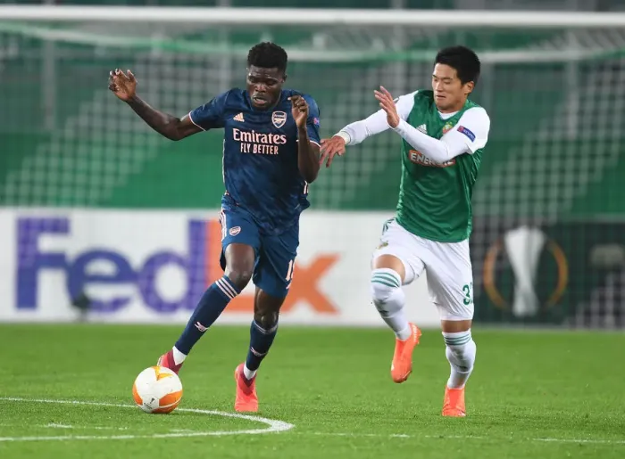 Framed Print : Thomas Partey Breaks Past Rapid Wien's Koya Kitagawa in Arsenal's UEFA Europa League Clash