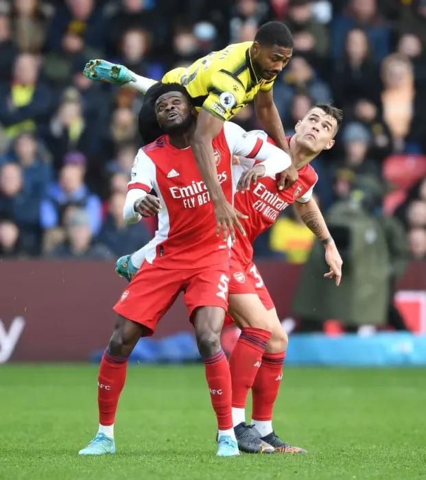 Framed Print : Thomas Partey and Granit Xhaka Clash with Emmanuel Dennis in Intense Watford vs. Arsenal Premier League Encounter