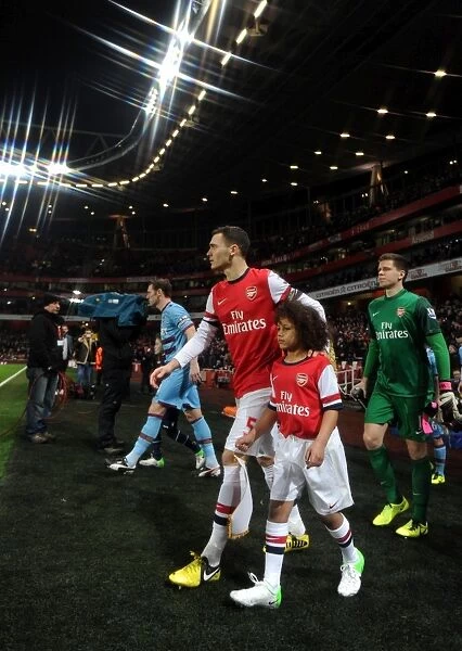 Thomas Vermaelen (Arsenal) walks out onto the pitch with the mascot. Arsenal 5:1 West Ham United
