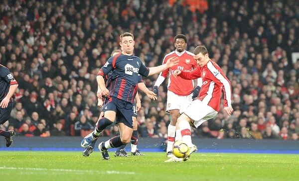 Thomas Vermaelen shoots past Bolton defender Gary Cahill to score the 3rd Arsenal goal