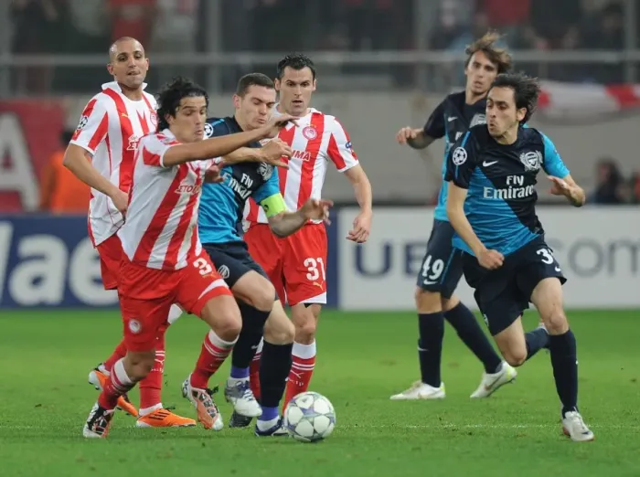 Framed Print : Thomas Vermaelen vs. Yossi Benayoun and Franck Modest: Intense Clash Between Olympiacos and Arsenal FC in the UEFA Champions League Framed Print : Thomas Vermaelen vs. Yossi Benayoun and Franck Modest: Intense Clash Between Olympiacos and Arsenal FC in the UEFA Champions League