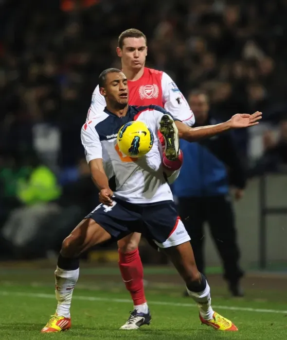 Framed Print : Thomas Vermaelen vs. David Ngog: Intense Tackle at Bolton Wanderers vs. Arsenal (2011-12)