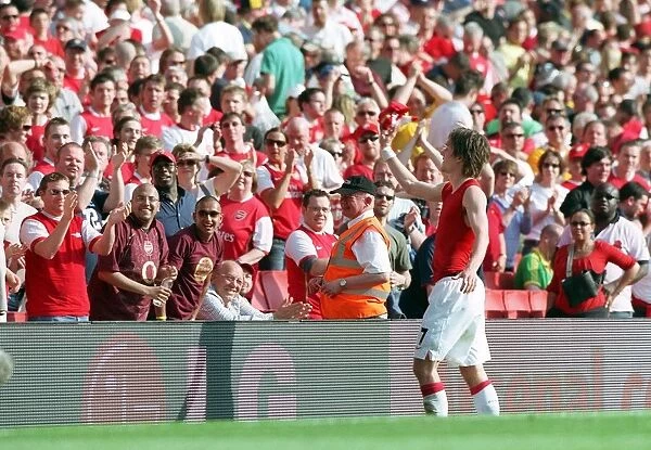 Tomas Rosicky (Arsenal) throws his shirt to the fans after the match