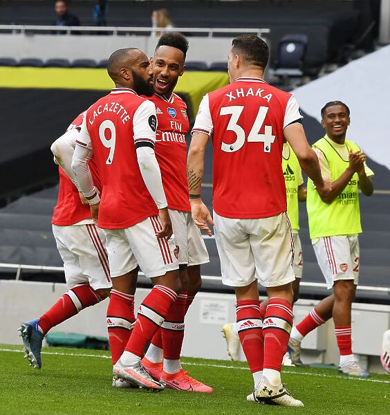 Triumphant Threesome: Lacazette, Aubameyang, and Xhaka's Victory Celebration (Arsenal vs. Tottenham, 2019-2020)