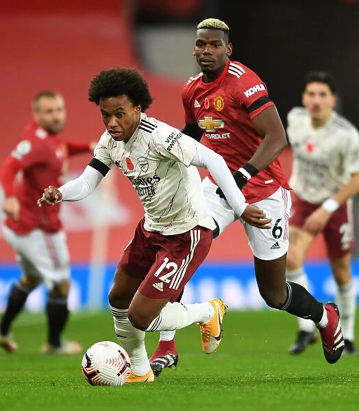Willian vs. Pogba: A Battle in Empty Old Trafford - Premier League 2020-21: Arsenal's Willian Clashes with Manchester United's Pogba in Ghostly Atmosphere of Old Trafford