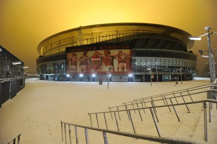 Framed Print : Winter's Battle at Emirates: Arsenal vs. Blackburn Rovers Amidst a Snow-Covered Stadium