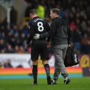 Aaron Ramsey Injured: Arsenal's Midfielder Carried Off the Pitch by Physio Colin Lewin During Burnley vs Arsenal Match Aaron Ramsey Injured: Arsenal's Midfielder Carried Off the Pitch by Physio Colin Lewin During Burnley vs Arsenal Match