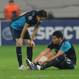 Andre Santos Holds Injured Ankle as Yossi Benayoun Looks On: Olympiacos vs. Arsenal, UEFA Champions League, 2011