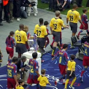 The Arsenal and Barcelona teams walk out past the European Cup The Arsenal and Barcelona teams walk out past the European Cup