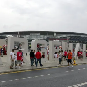 Arsenal fans gather outside the Emirates Stadium on thegiant letters near the south bridge