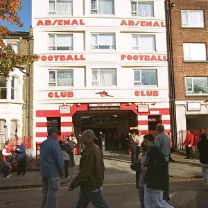 Arsenal fans walk outside the entrance to the West Stand Upper before the match