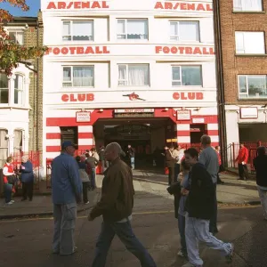 Arsenal fans walk outside the entrance to the West Stand Upper before the match