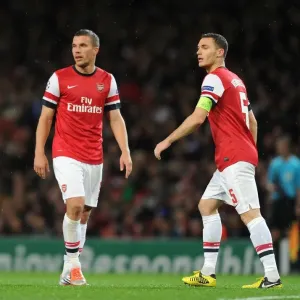 Arsenal FC vs Olympiacos FC: Lukas Podolski and Thomas Vermaelen in Action during the 2012-13 UEFA Champions League Match