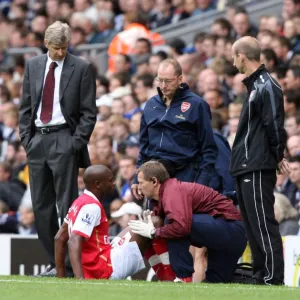 Arsenal manager Arsene Wenger looks on as injured captain William Gallas is treated by Gary Lewin