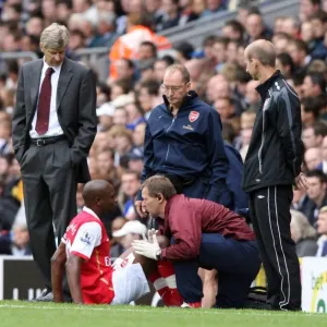 Arsenal manager Arsene Wenger looks on as injured captain William Gallas is treated by Gary Lewin