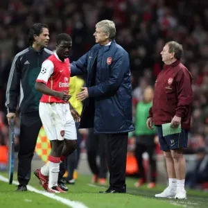 Arsenal manager Arsene Wenger pats Emmanuel Eboue on the back after his substitution
