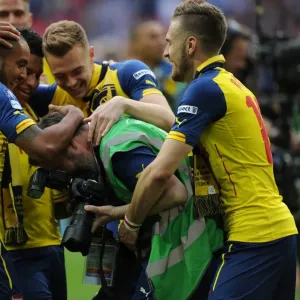 Arsenal photographer Stuart MacFarlane is grabbed by Aaron Ramsey and Theo Walcott after the match Arsenal photographer Stuart MacFarlane is grabbed by Aaron Ramsey and Theo Walcott after the match