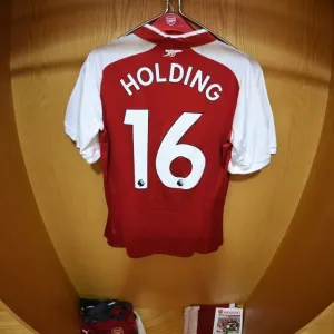 Arsenal: Rob Holding's Emirates Jersey in the Home Changing Room Before Arsenal vs Leicester City (2017-18) Arsenal: Rob Holding's Emirates Jersey in the Home Changing Room Before Arsenal vs Leicester City (2017-18)