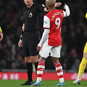 Arsenal vs. Liverpool: Lacazette and Referee Marriner in Intense Discussion during the Premier League Clash at Emirates Stadium