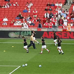 Arsenal warm up in front of the Arsenal For Everyone boards