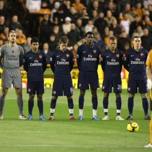 The Arsenal and Wolves teams observe a minutes silence