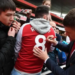 Arsenal's Aaron Ramsey Celebrates with Fans after Securing Victory over Brighton & Hove Albion Arsenal's Aaron Ramsey Celebrates with Fans after Securing Victory over Brighton & Hove Albion