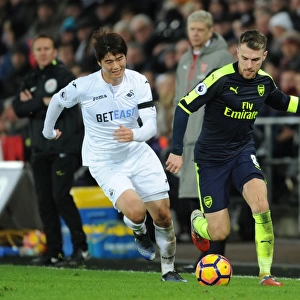 Arsenal's Aaron Ramsey Outmaneuvers Swansea's Ki Sung-Yueng in Premier League Clash