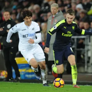 Arsenal's Aaron Ramsey Outmaneuvers Swansea's Ki Sung-Yueng in Premier League Clash Arsenal's Aaron Ramsey Outmaneuvers Swansea's Ki Sung-Yueng in Premier League Clash