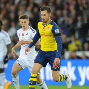 Arsenal's Aaron Ramsey Outmaneuvers Swansea's Tom Carroll