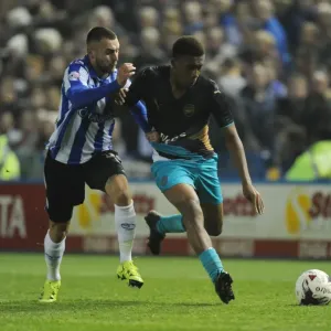 Arsenal's Alex Iwobi Goes Head-to-Head with Sheffield Wednesday's Jack Hunt in Capital One Cup Clash
