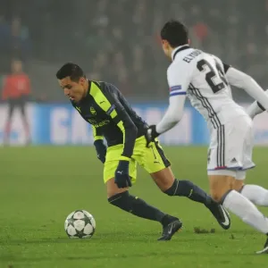Arsenal's Alexis Sanchez Faces Off Against Basel's Mohamed Elyounoussi and Geoffroy Serey in 2016-17 UEFA Champions League Clash Arsenal's Alexis Sanchez Faces Off Against Basel's Mohamed Elyounoussi and Geoffroy Serey in 2016-17 UEFA Champions League Clash