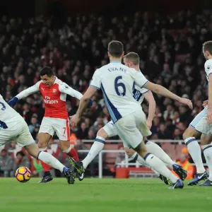 Arsenal's Alexis Sanchez Goes Head-to-Head with Claudio Yacob and Jonny Evans in Intense Football Battle