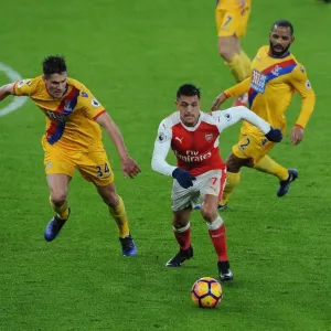 Arsenal's Alexis Sanchez Goes Head-to-Head with Martin Kelly and Jason Puncheon of Crystal Palace Arsenal's Alexis Sanchez Goes Head-to-Head with Martin Kelly and Jason Puncheon of Crystal Palace