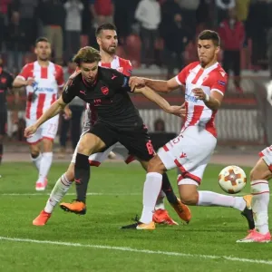 Arsenal's Ben Sheaf Clashes with Filip Stojkovic and Srdan Babic of Red Star Belgrade in Europa League Match