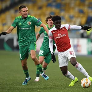 Arsenal's Bukayo Saka Clashes with Vyacheslav Sharpar of Vorskla in Europa League Match