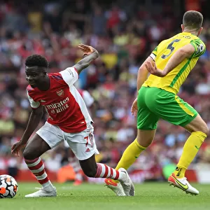 Arsenal's Bukayo Saka Dodges Norwich's Hanley in Thrilling 2021-22 Premier League Clash