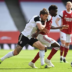 Arsenal's Bukayo Saka Faces Off Against Fulham's Joe Bryan in Empty Emirates Stadium, Premier League 2020-21