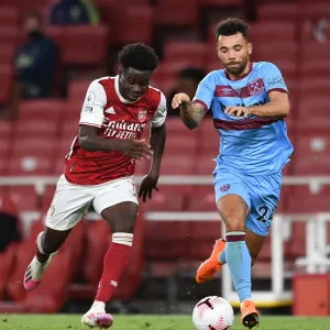 Arsenal's Bukayo Saka Faces Off Against West Ham's Ryan Fredericks in Premier League Clash