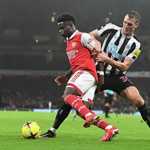 Arsenal's Bukayo Saka Fends Off Newcastle's Dan Burn in Premier League Clash