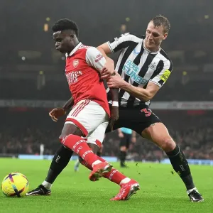 Arsenal's Bukayo Saka Fends Off Newcastle's Dan Burn in Premier League Clash