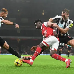 Arsenal's Bukayo Saka Fends Off Newcastle's Joelinton and Dan Burn during the Arsenal v Newcastle United Premier League Match, 2023