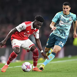 Arsenal's Bukayo Saka Fends Off Southampton's Mohamed Elyounoussi in Intense Premier League Clash