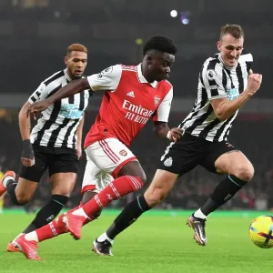 Arsenal's Bukayo Saka Outmaneuvers Newcastle's Dan Burn in Premier League Clash