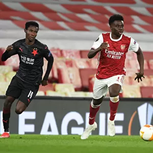 Arsenal's Bukayo Saka Outmaneuvers Slavia Praha's Oscar Dorley in UEFA Europa League Quarterfinal at Empty Emirates Stadium