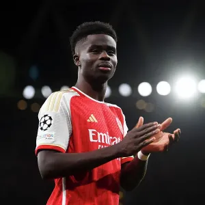 Arsenal's Bukayo Saka Salutes Appreciative Fans after a Hard-Fought UEFA Champions League Match vs Sevilla (2023-24)