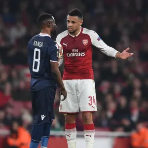 Arsenal's Coquelin Engages with Red Star's Kanga during Europa League Clash