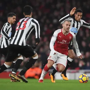Arsenal's Jack Wilshere Clashes with Newcastle's Midfield Trio during Premier League Match